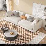 an aerial view of a living room with couches, coffee table and pictures on the wall