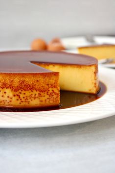 a piece of cheesecake on a plate with chocolate sauce and nuts in the background