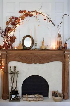 a fireplace with candles, branches and other decorations