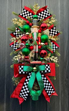 a christmas wreath hanging on the side of a wooden door with ornaments and decorations around it