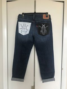 It's a buggy world out there with these dynamic painted jeans! Each back pocket features a beetle in contrasting black and white for the ultimate POP! Every pair of jeans is painted using high-quality acrylic paint and fabric medium to ensure long-lasting bold colors. With proper gentle care, these jeans will be sure to last you a long time. - Size 26 - Levi's Boyfriend Style - Dark wash Handwash Only to ensure the colors last. Black Recycled Denim Jeans With Pockets, Black Jeans With Pockets In Recycled Denim, Painted Jeans, Boyfriend Style, Womens Jeans, Beetles, Fabric Medium, Rock Revival Jean, Acrylic Paint