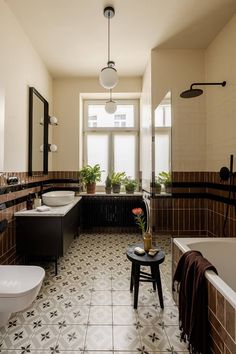 a bathroom with two sinks, toilet and bathtub in the center is tiled floor