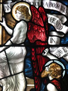 a stained glass window with an angel holding a cross in it's left hand