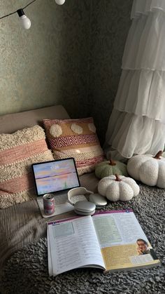 a laptop computer sitting on top of a bed next to pillows