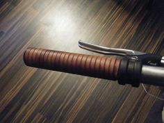 a close up of a bicycle handlebar on a wooden floor with woodgrain