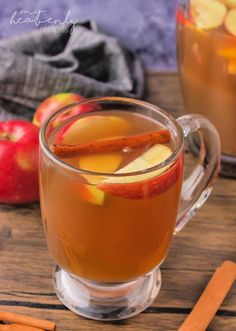 two mugs filled with apple cider and cinnamon sticks