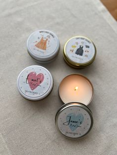 three small tins with candles sitting on top of a table next to each other