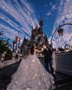 a bride and groom pose in front of the castle at disney's magic kingdom