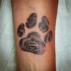 a dog paw tattoo on the left arm