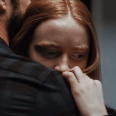 a man and woman embracing each other in front of a mirror with their eyes closed