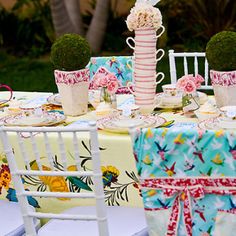 the table is set with tea cups, plates and napkins for an afternoon tea party