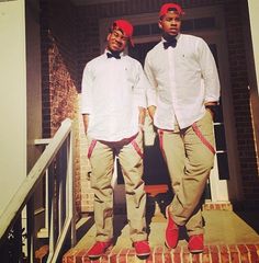 two men in white shirts and bow ties standing on steps with their hands behind their backs