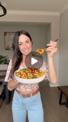 a woman holding a bowl of food in her hands