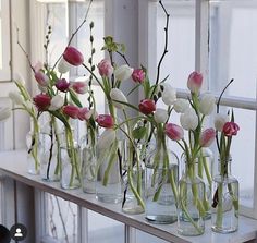 several vases filled with flowers sitting on a window sill