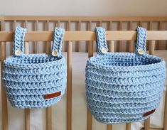 two crocheted baskets hanging from the side of a crib