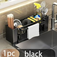 a kitchen sink with utensils and cleaning supplies in the bottom drawer next to it