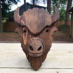 a wooden sculpture of a bull's head on top of a wood plank table