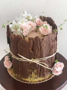 a chocolate cake decorated with flowers and leaves