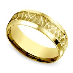 a yellow gold wedding ring with hammered texture inlayed to it's surface