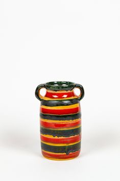 a striped vase with a black handle on a white background