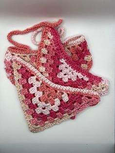 a crocheted pink and white purse sitting on top of a white countertop