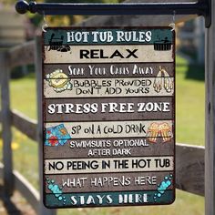 a sign hanging from the side of a wooden fence that says hot tub rules relax