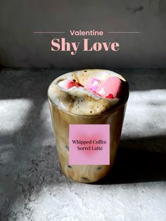 a cup filled with whipped coffee topped with marshmallows and pink candy hearts