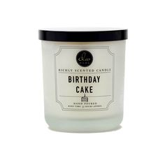 a birthday cake candle sitting on top of a white tablecloth next to a black lid