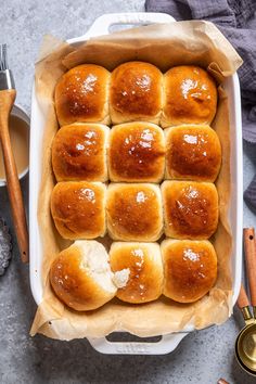 baked rolls in a baking dish with butter and cinnamon on the side, ready to be eaten