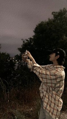 a man in plaid shirt holding a white frisbee on top of a field