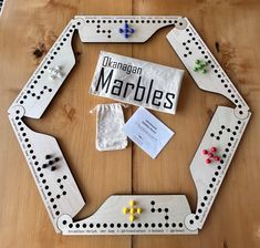 a wooden board game set up on top of a table with pieces of paper and magnets