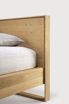 a wooden bed frame with two pillows on it