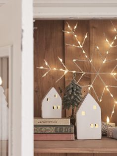 a shelf with books and christmas lights on it