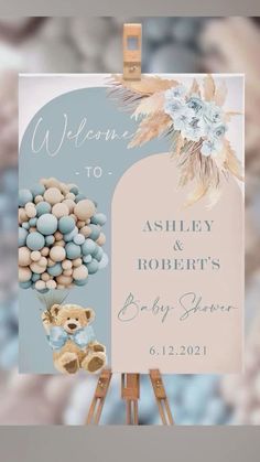 a welcome sign for a baby shower with teddy bears and flowers on it's easel