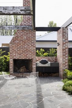 an outdoor fireplace with chairs around it