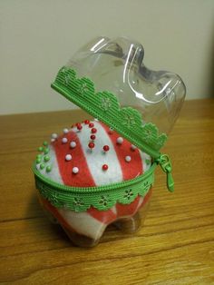 a glass container with a red and white striped design on it sitting on a wooden table