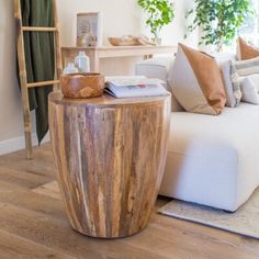 a wooden table sitting on top of a hard wood floor next to a white couch