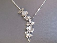 "\"Gently Falling Blossoms\" This necklace is stunning. The pendants have been arranged in an asymmetric design to form a beautiful, flowing cascade of flowers. Gorgeous! The pendants are each made of 3 individual flower charms which have been connected and plated in a white gold finish. They have nice movement and are highly detailed. Each pendant (3 flowers) measures 34mm (1.3\") long, and they are connected to a fine silver plated chain which closes with a lobster clasp. The chain length of t Flower Necklace Silver, Gold Orchid, Silver Flower Necklace, Jewelry Bridal, Gold Necklace Women, Bridesmaid Necklace, White Jewelry, Silver Flowers, Bridesmaid Jewelry