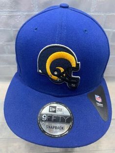 the new era snapback hat is blue and has a rams logo on it