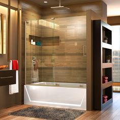 a bathroom with a glass shower door and wooden flooring, along with a rug on the floor