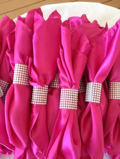 the back of a chair covered in pink fabric and diamond sashes with silver buckles