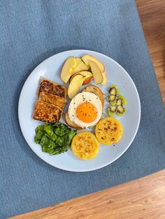 a white plate topped with eggs, toast and other foods on top of a wooden table