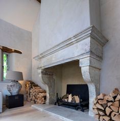 a fireplace with logs stacked in front of it