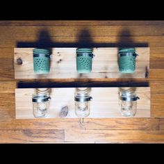 mason jars are lined up on a wooden shelf