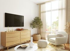 a living room filled with furniture and a flat screen tv on top of a wooden dresser