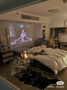 a bed room with a large screen on the wall