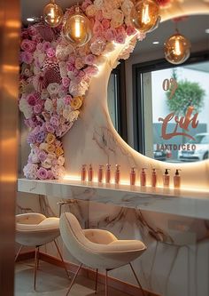 the interior of a beauty salon with flowers on the wall