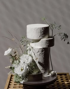 three tiered cake with white flowers and greenery