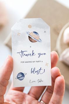 a hand holding a thank you for making my party a blast with the planets on it