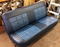 a blue leather couch sitting in a warehouse